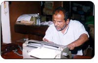 Photograph of a blind man typing a document